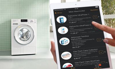 Miele Reinigungsmittel für die Wäsche, in Flaschen und Packungen, ordentlich auf einem Regal im Hauswirtschaftsraum, bereit zur Verwendung